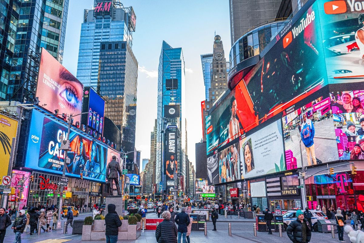 Tourists are visiting the Times Square with colorful lights in Manhatan.