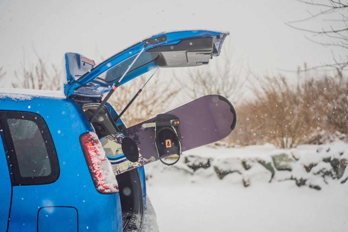 A snowboard sticking out to the car.