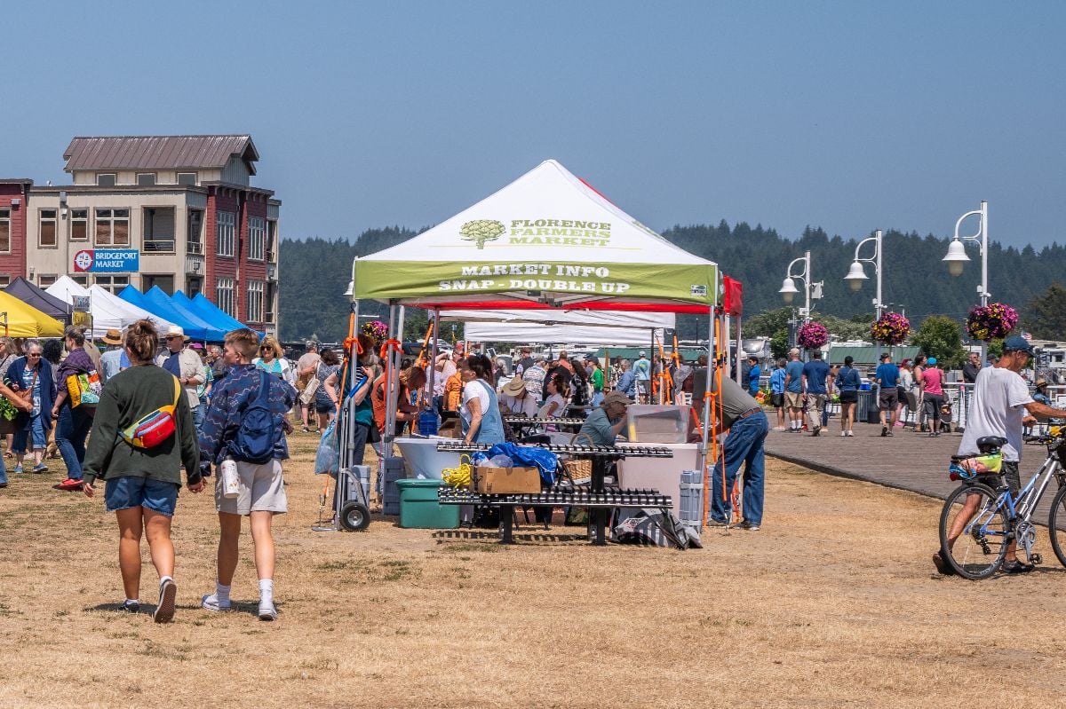 Farmers market with people shopping on the boardwalk.