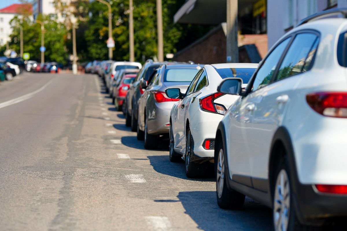 Cars parked tight along the roadside.