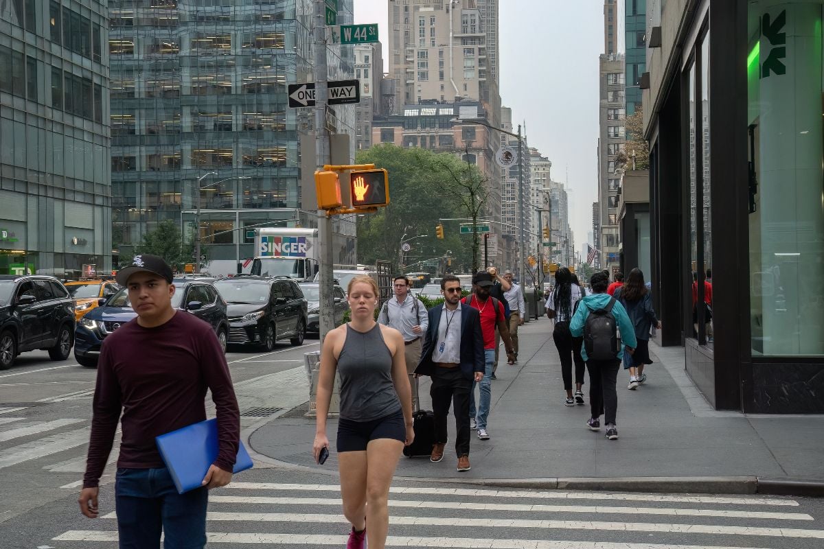 Pedestrians jaywalking on a signaled road crossing.