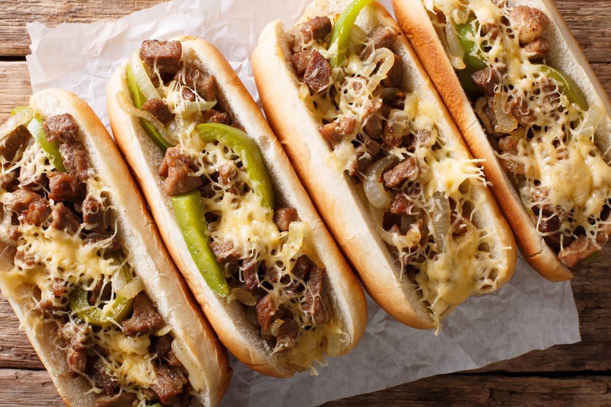Philadelphia cheesesteak sandwich close-up on the rustic table.