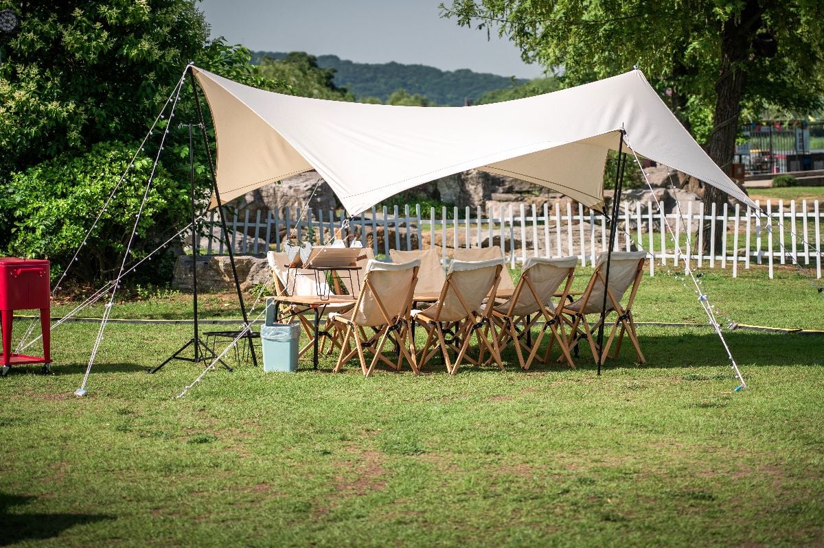 Outdoor camping equipment including chairs and a tent.