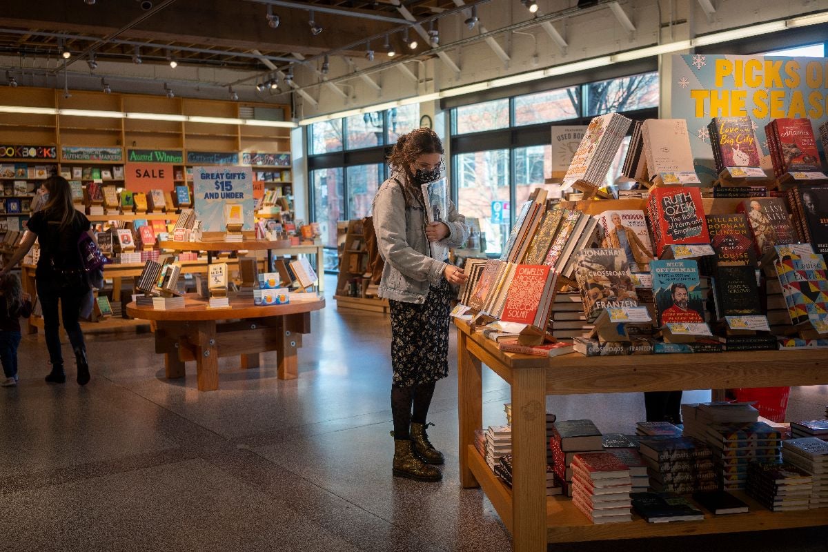 A masked customer browses the books on display in the Powell's City of Books store.