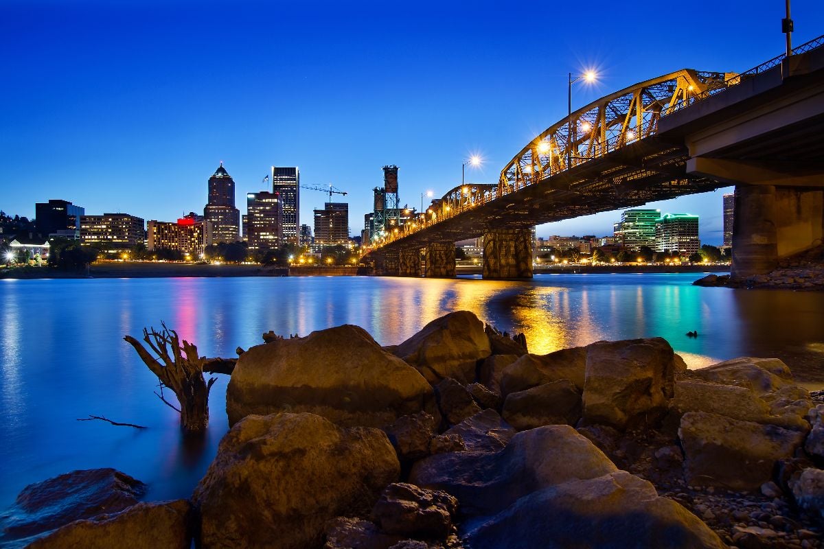 Portland Oregon City skyline along Willamette River at blue hour.
