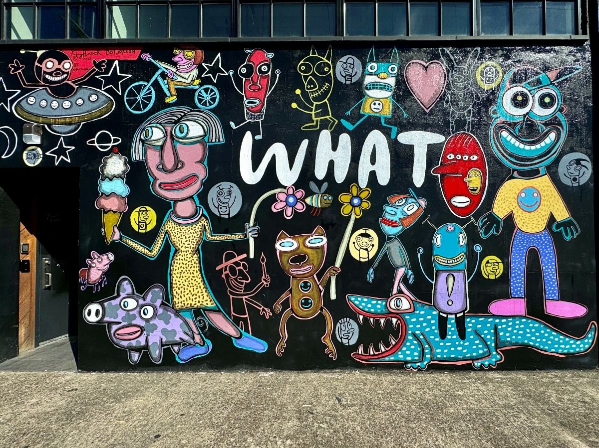 Colorful mural filled with quirky cartoon-style characters.