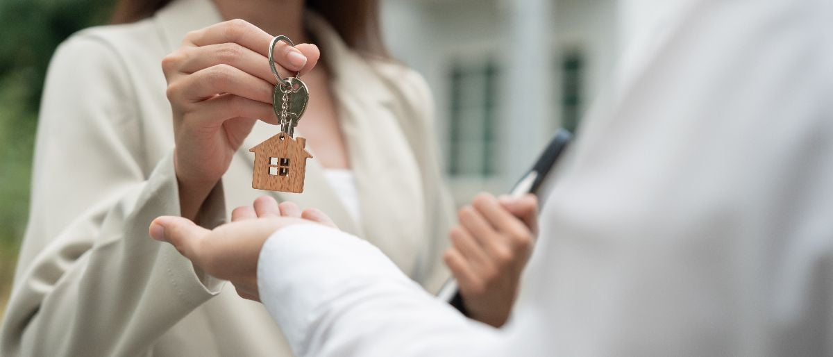 Real estate agent handing out keys to the new homeowners.