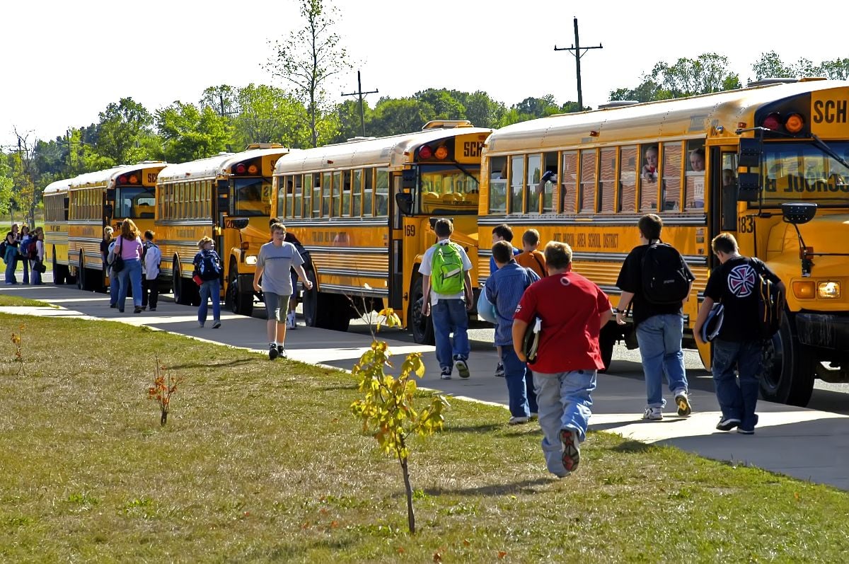 Middle school students riding school buses.