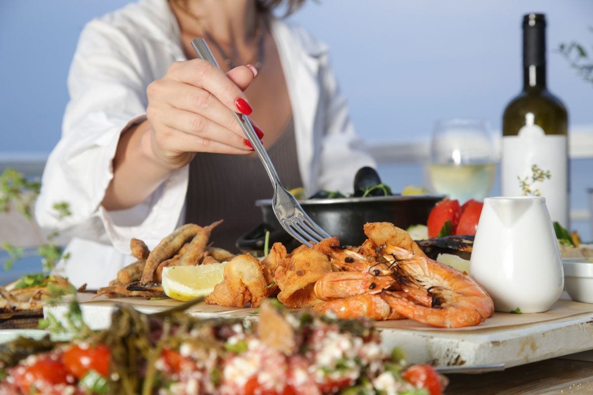 Woman enjoying seafood platter in the beach restaurant.