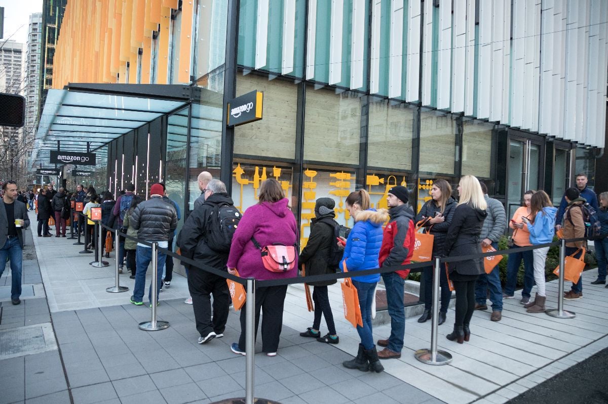 Wide angle view of a line of people wrapped around the block waiting to enter the Amazon Go store.