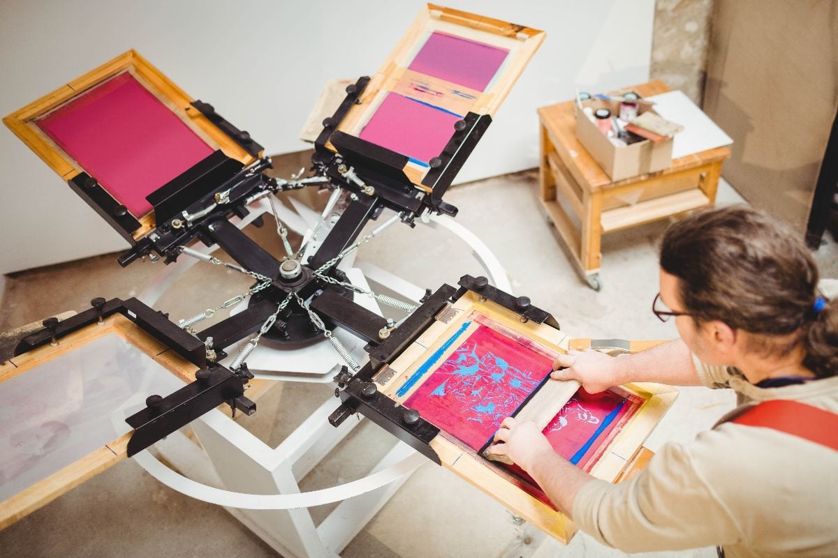 Screen printing press rotating on carousel in studio.