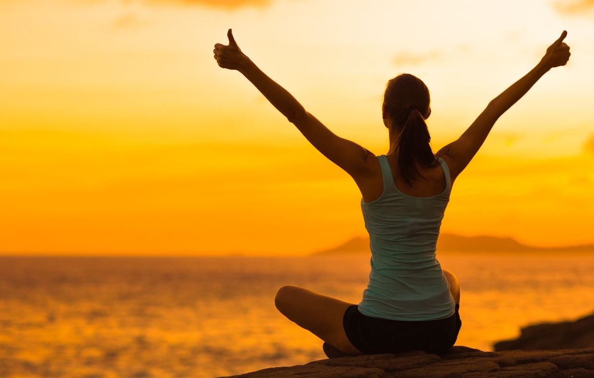 Woman celebrating during a beautiful sunset.