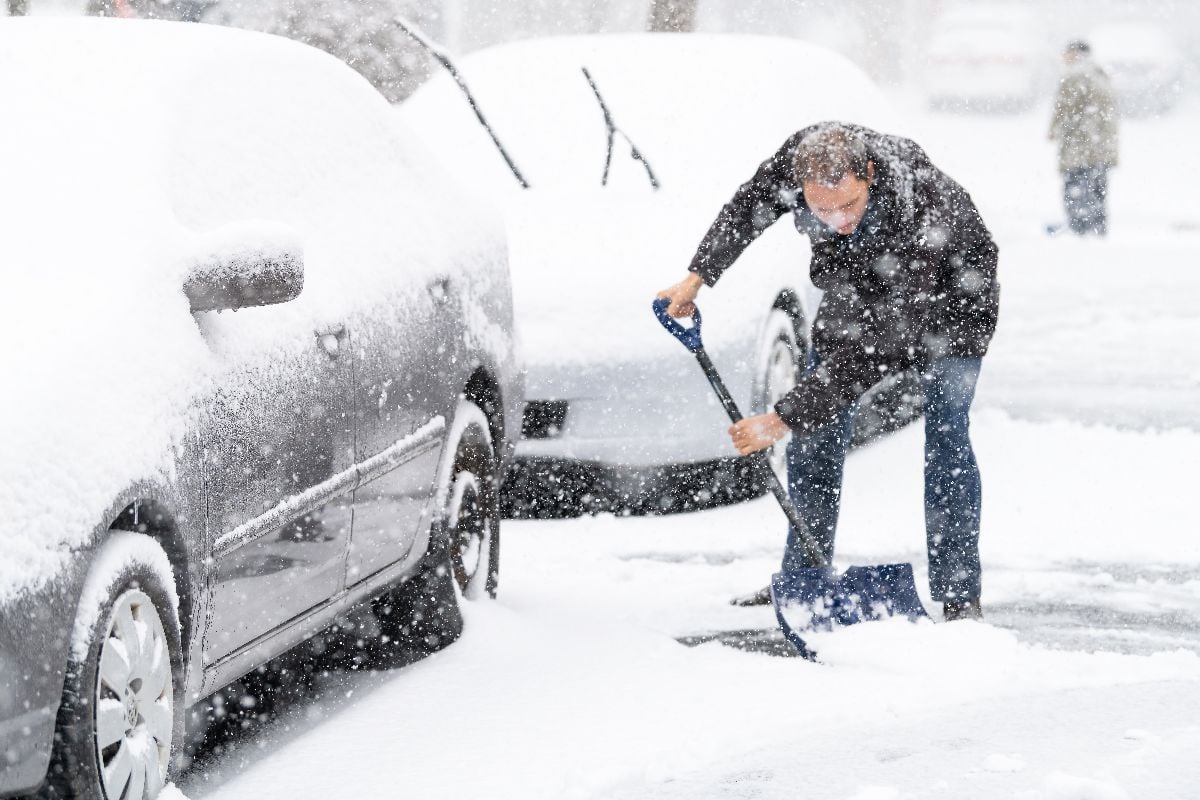 Man shoveling snow on the street.