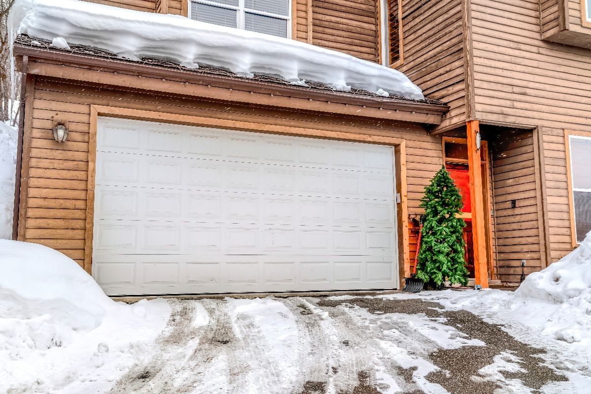 Snowy driveway in front of garage door.
