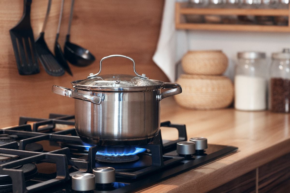 Stainless pan on the hob, cooking on a gas stove,