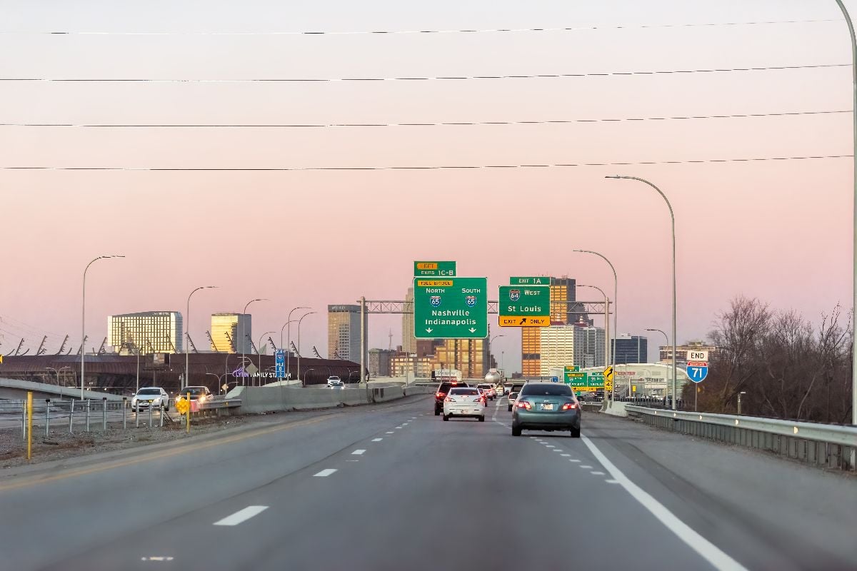 Kentucky city at sunset dusk dark night with sign on interstate for Nashville, Indianapolis and St Louis exit.