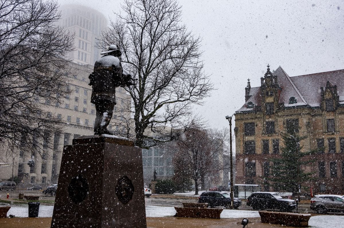 Fireman’s memorial stands facing St Louis city hall during snow storm.