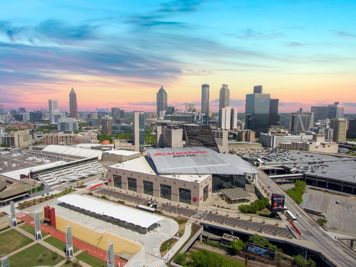 Aerial shot of State Farm Arena with skyscrapers and office buildings in the skyline.