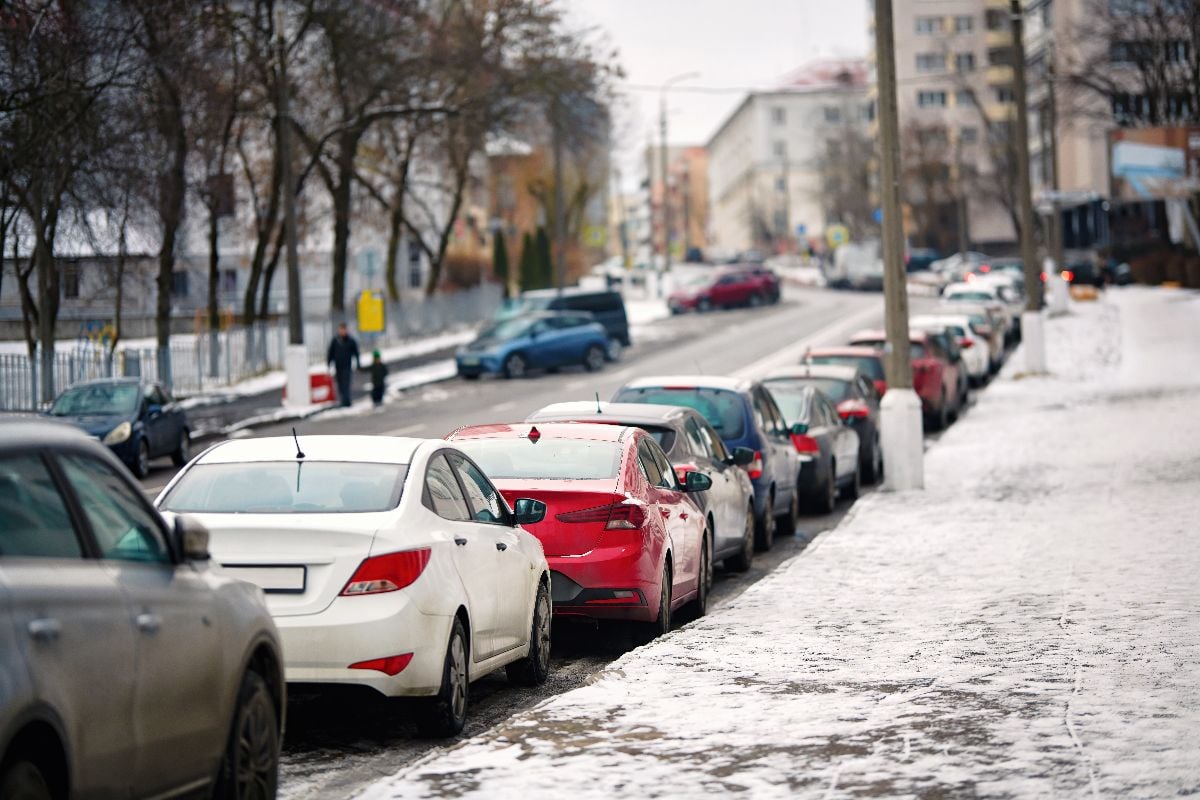 Cars parked on steep sloped road in the city.