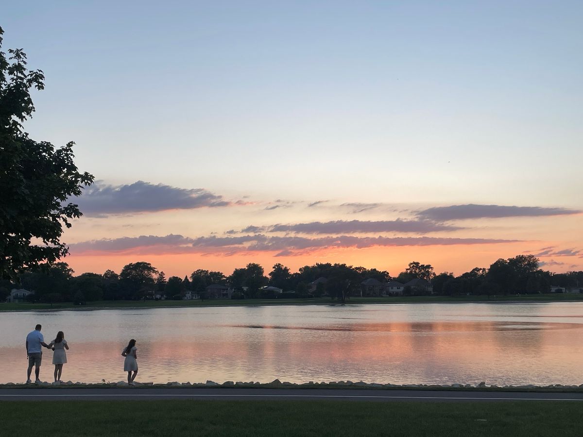 Family walking alongside a lake.