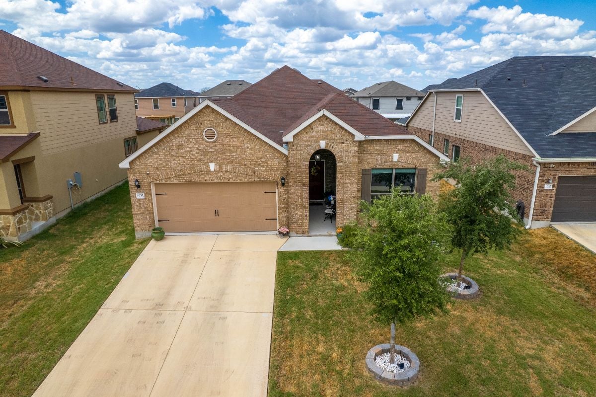 Bungalow brick house with yard and garage.