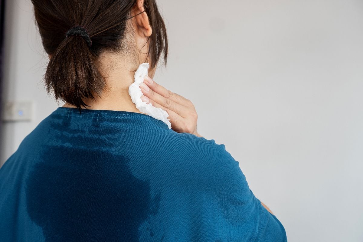 Woman struggling with sweat stain.