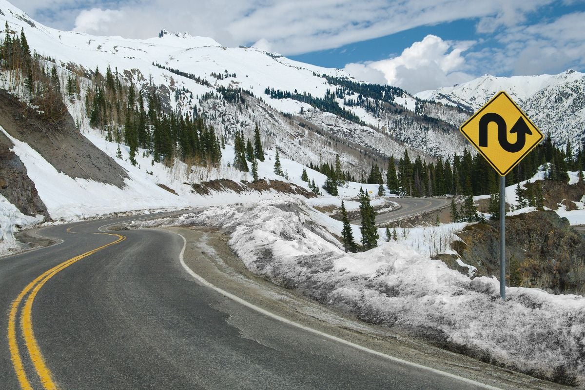 A sign warns of repeated sharp turns ahead on a mountain road in southwest Colorado.
