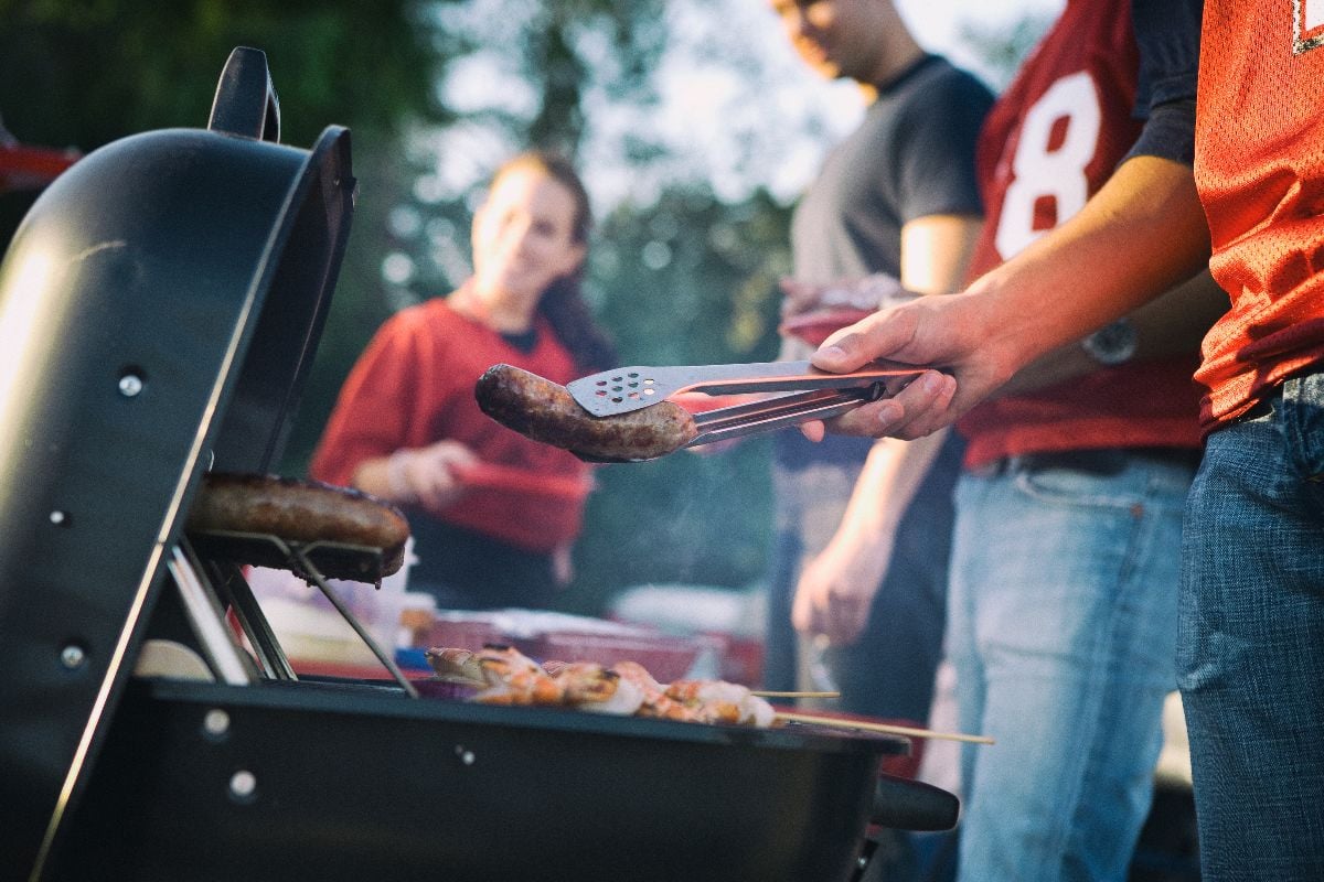 Man work the grill at tailgating party.