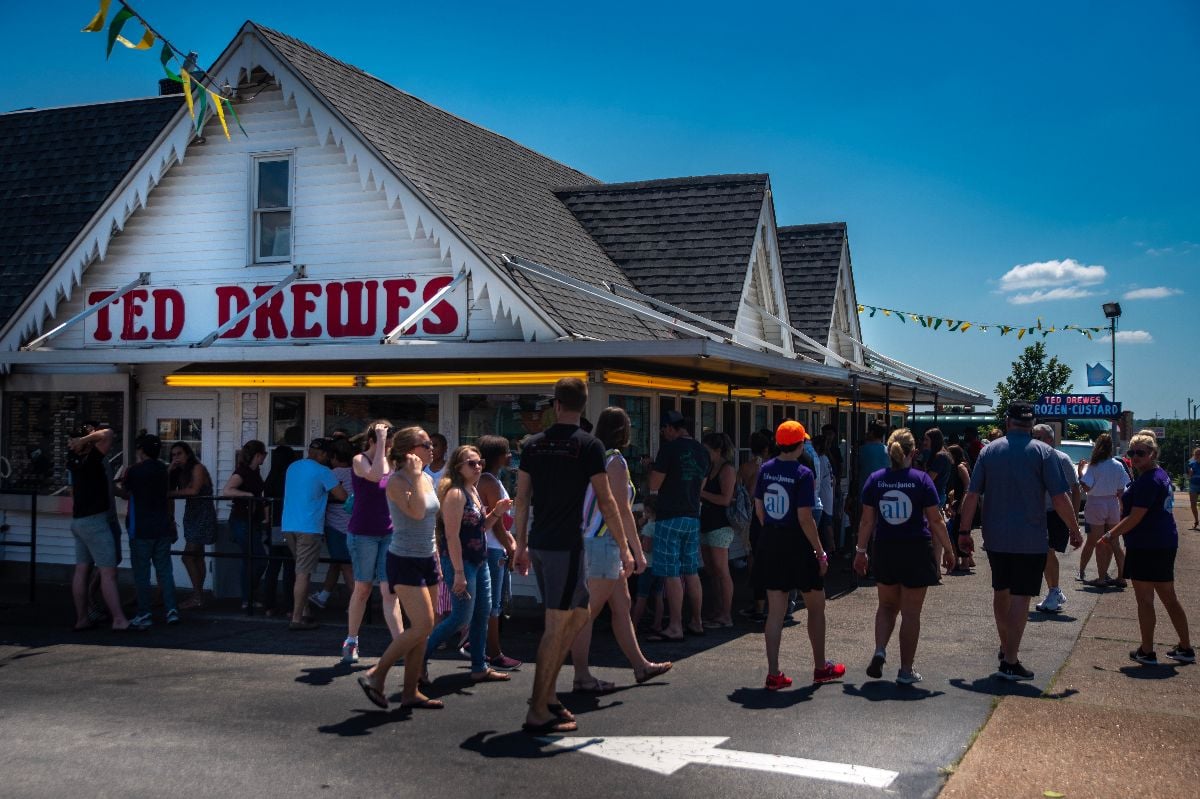 Patrons standing outside in lines at service windows at Ted Drews frozen custard and ice cream shop.