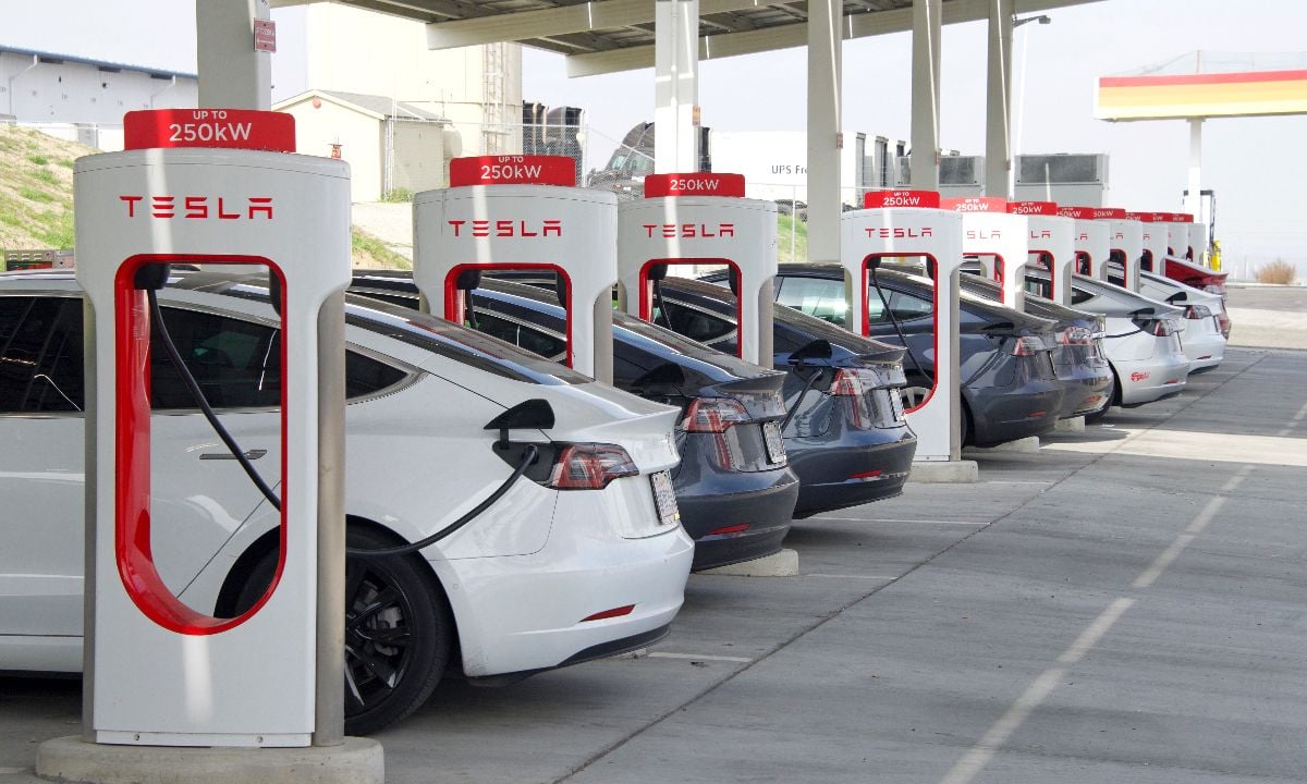 Electric vehicles charging at a Tesla Supercharger station.