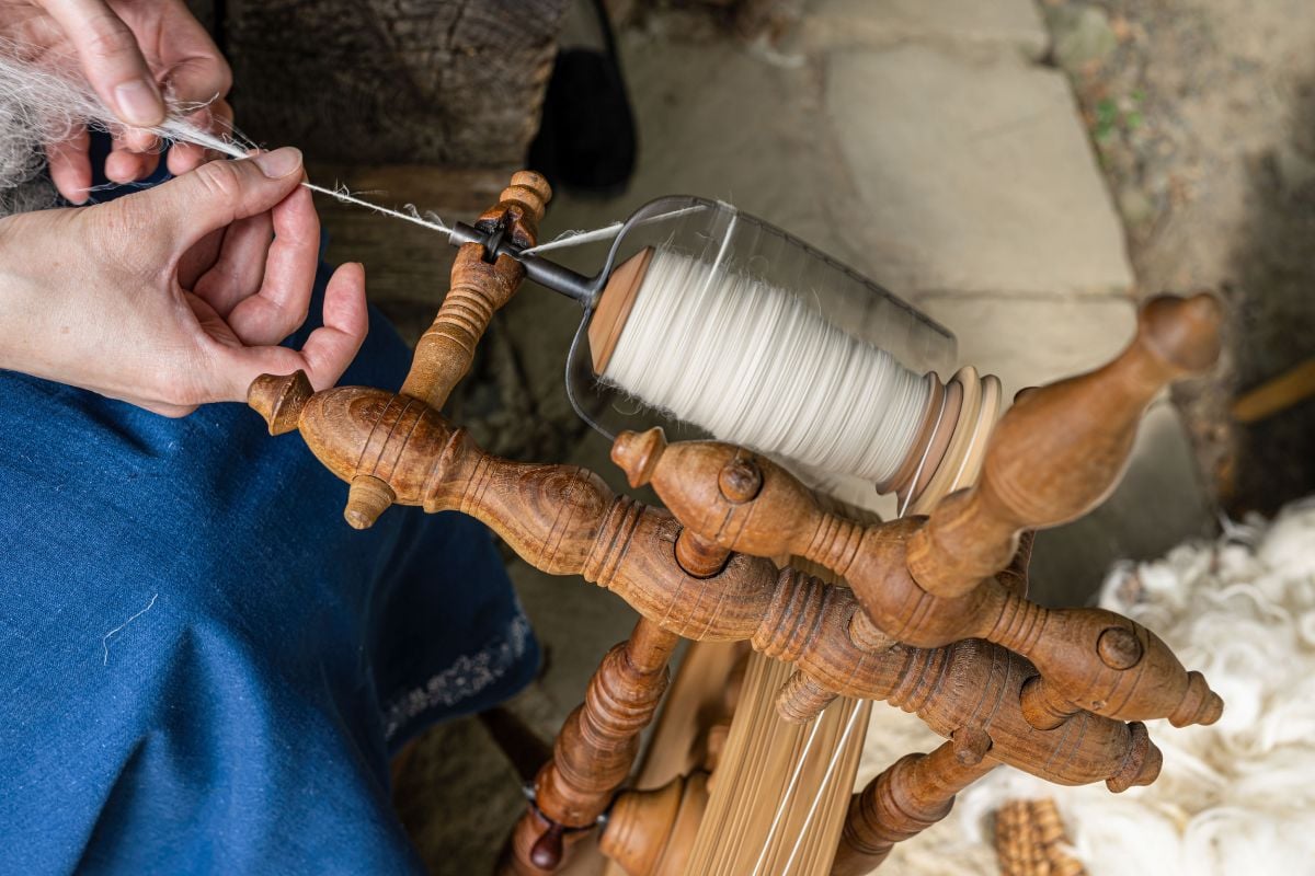 Thread maker making wool in a spinning wheel.