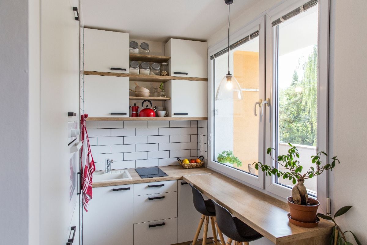 White tiny modern kitchen with built-in dining.