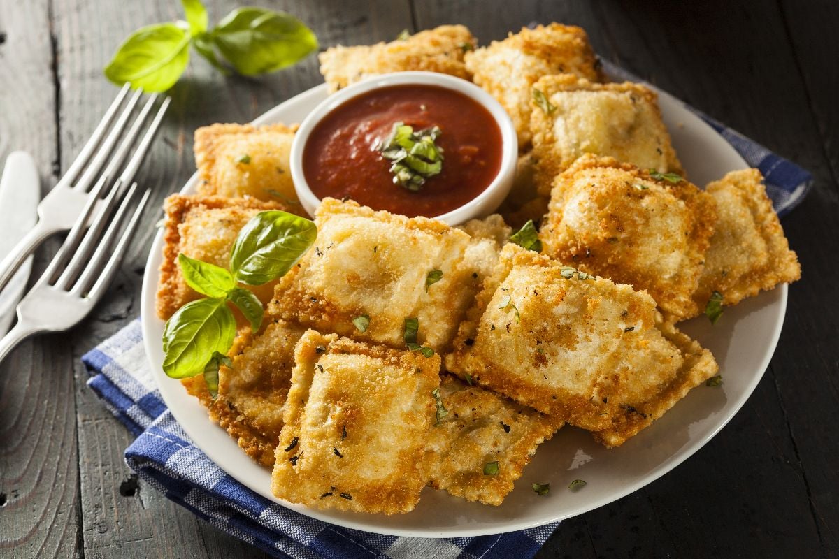 Homemade fried ravioli with marinara sauce and basil.