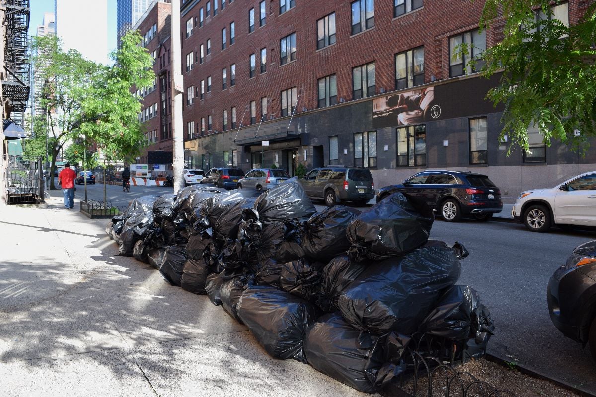 Piles of trash on sidewalk.