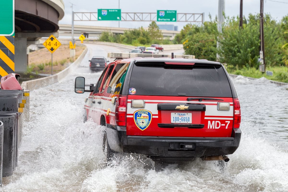 Houston emergency services with cars across the flooded street in Houston.