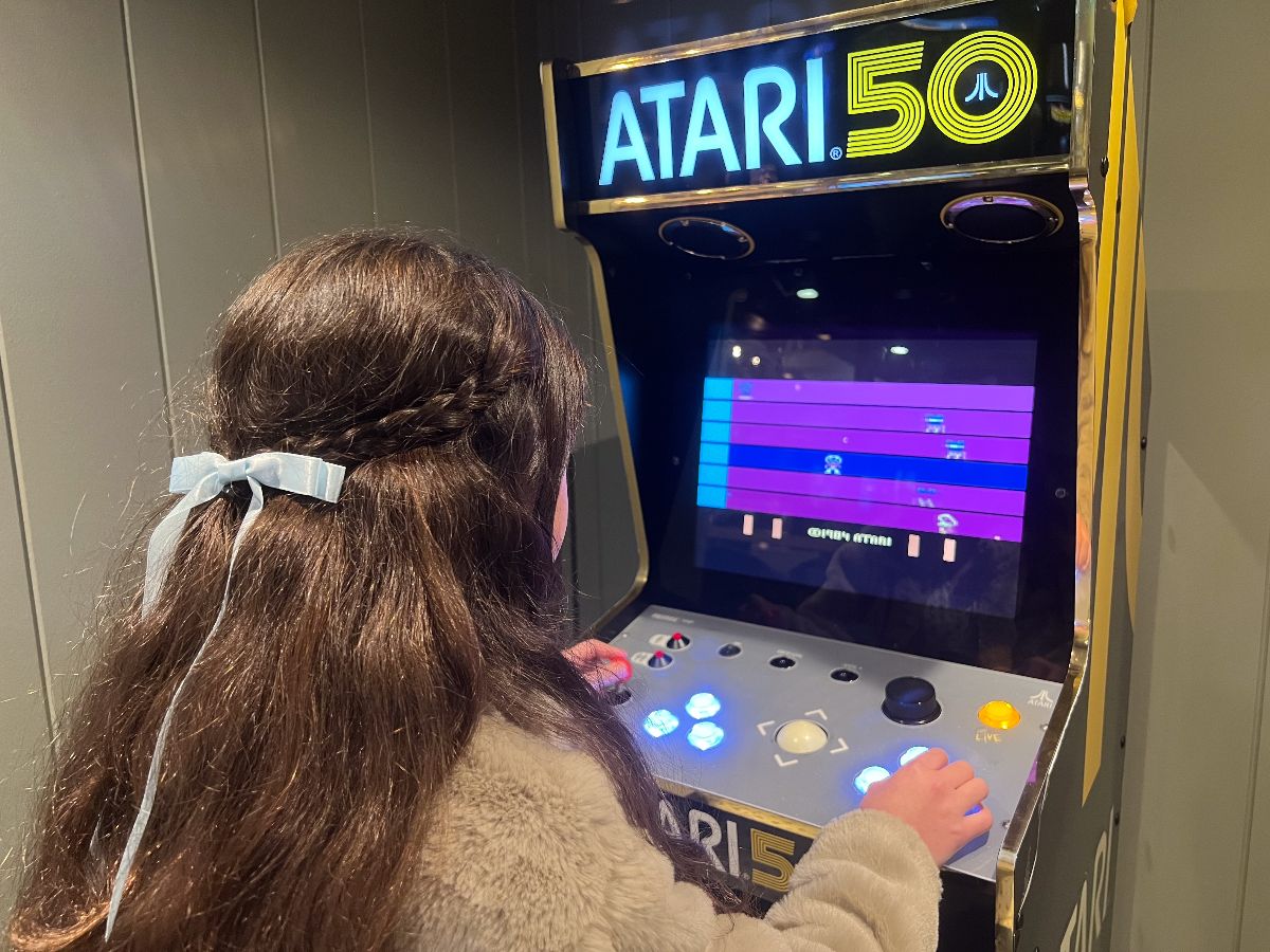 Young woman playing Atari Retro Arcade.