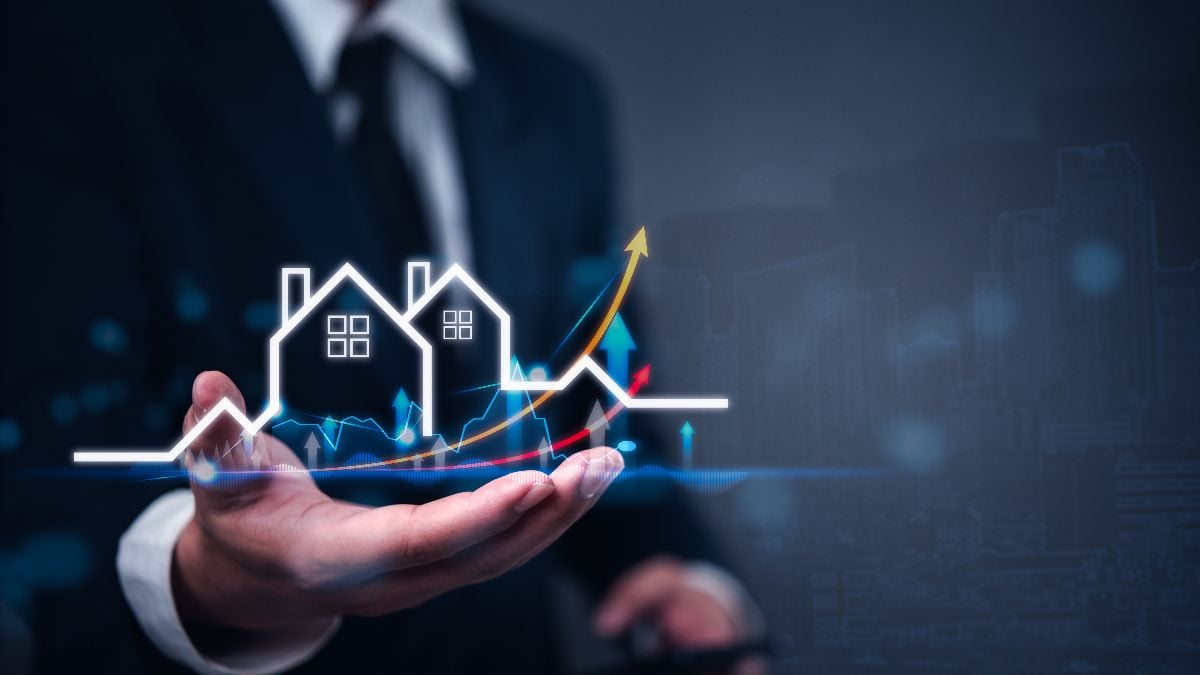 Businessman holding virtual graph showing real estate market growth.