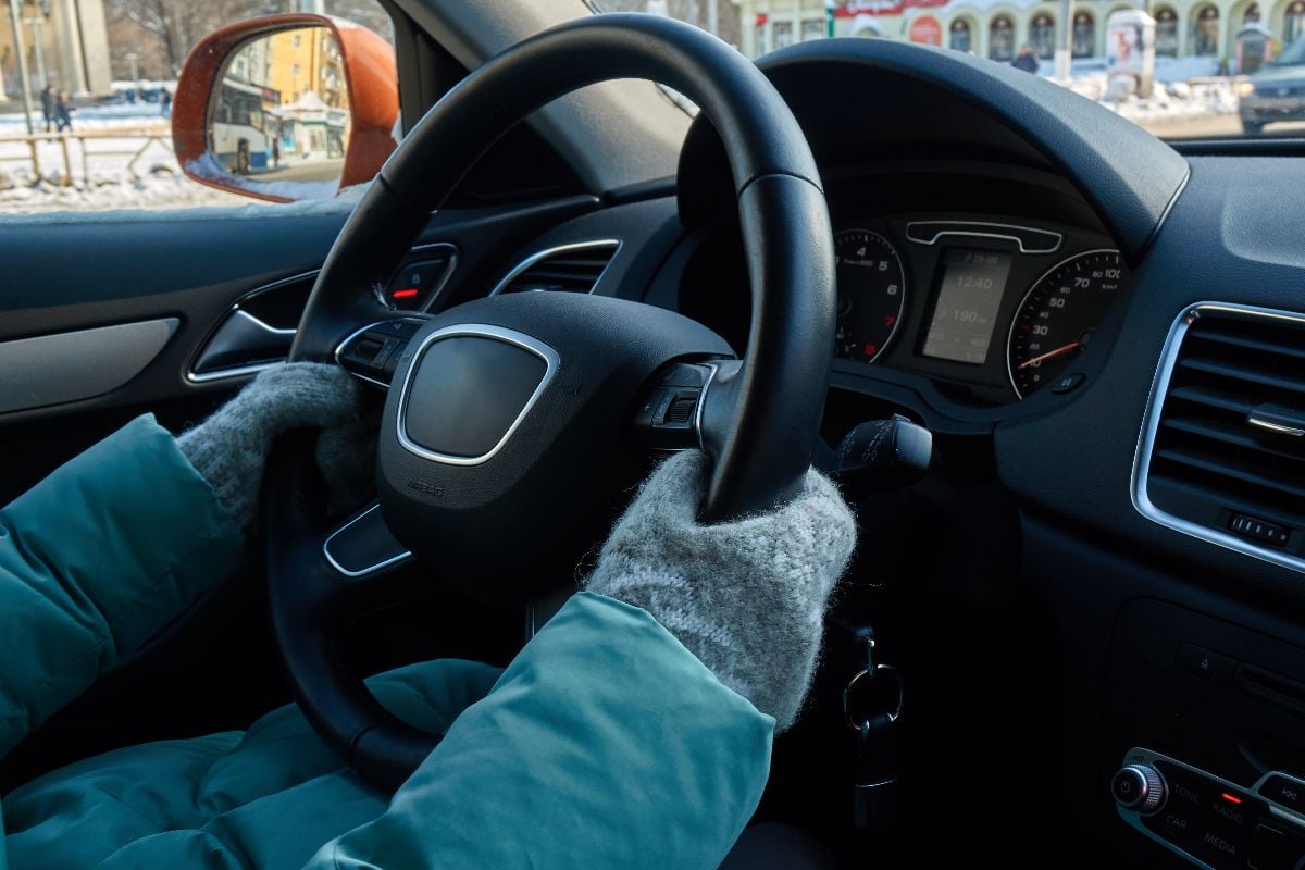 Woman warming up car during winter.