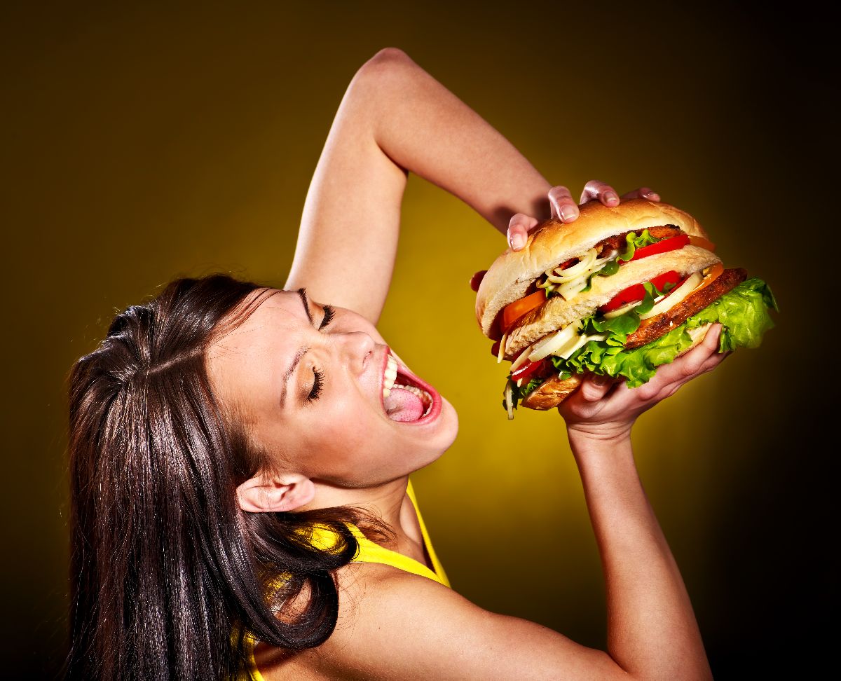 Woman holding huge hamburger.