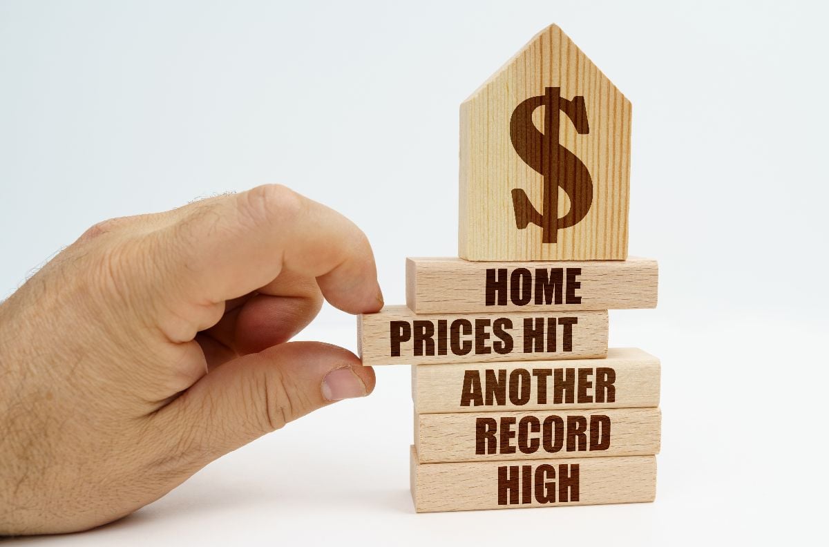 Hand holding wooden blocks with real estate related inscriptions.