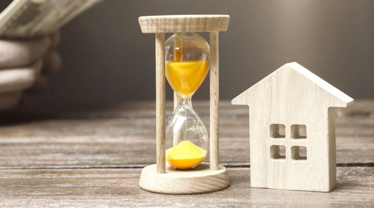 Hourglass beside a wooden house.