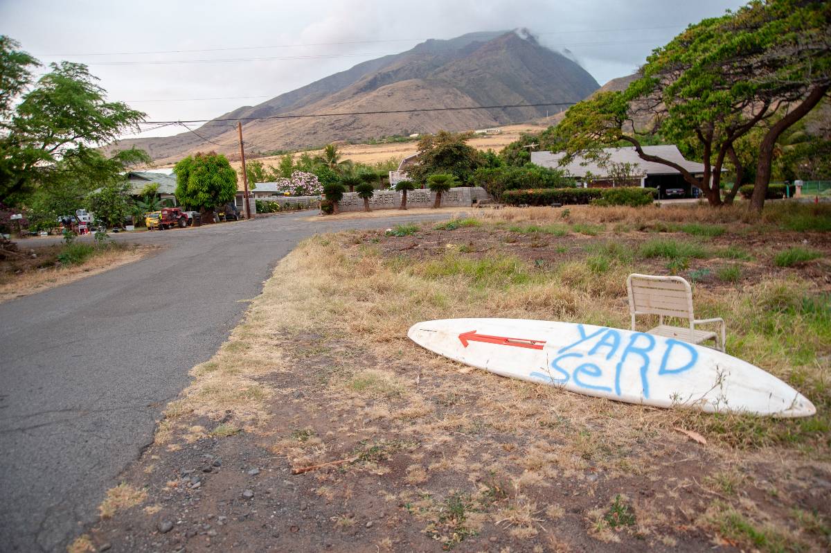 Roadside surfboard points to a local yard sale.