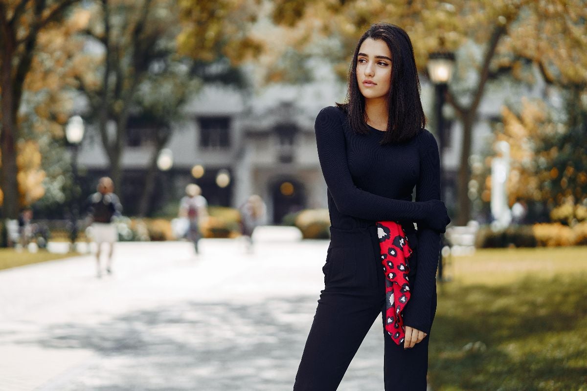 Woman wearing all black outfit outdoors.