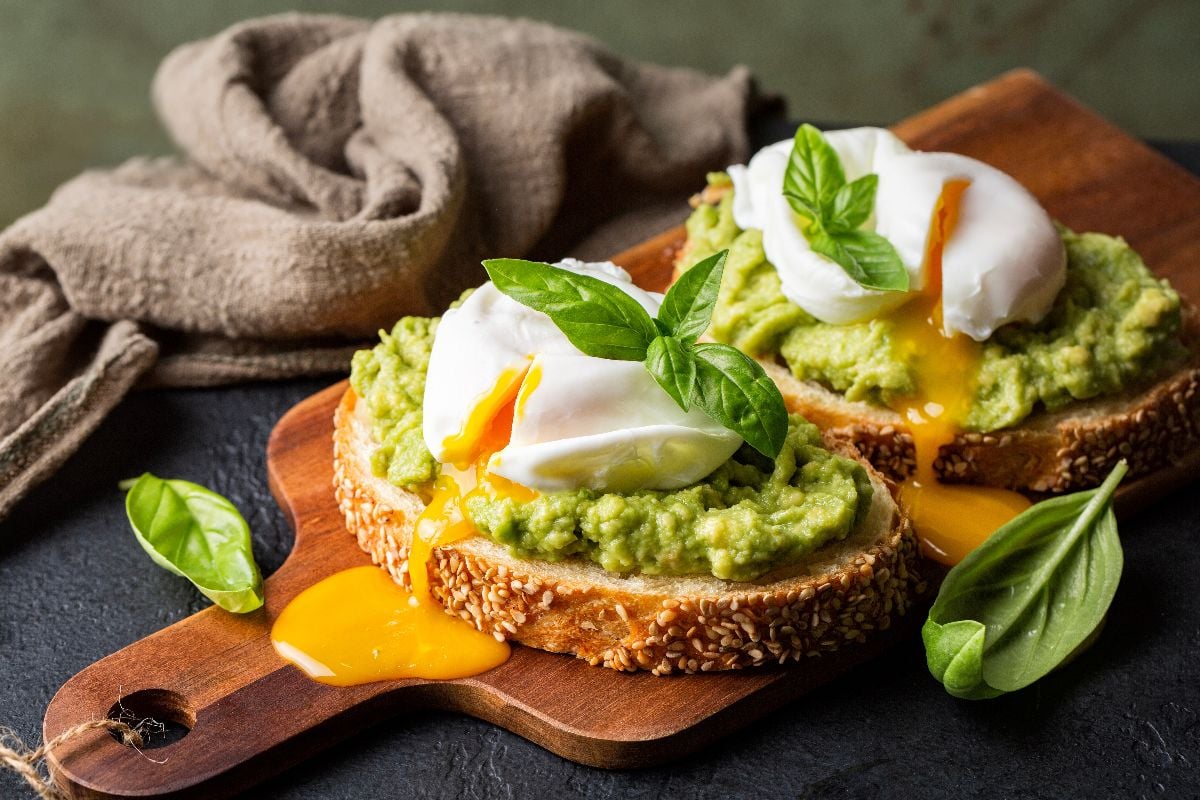 Smashed avocado sandwich with boiled poached egg.