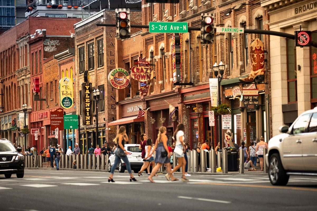 People walk along the businesses and bars on Broadway in Nashville.