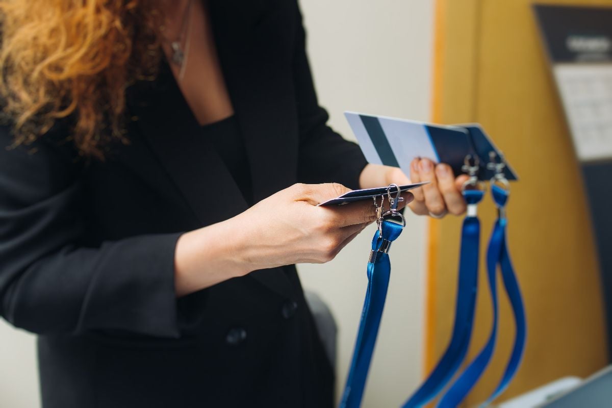 Business woman holding lanyard with name badge.