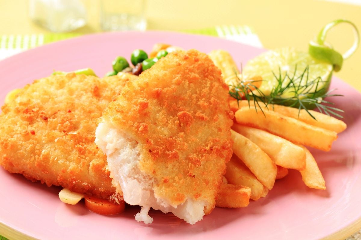 Fried fish and french fries with garnishing.