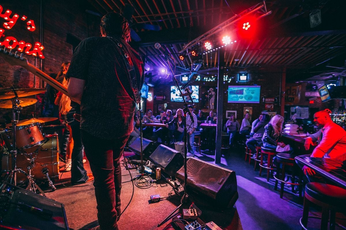 Band performing on stage in a Honky-tonk on Lower Broadway at night.