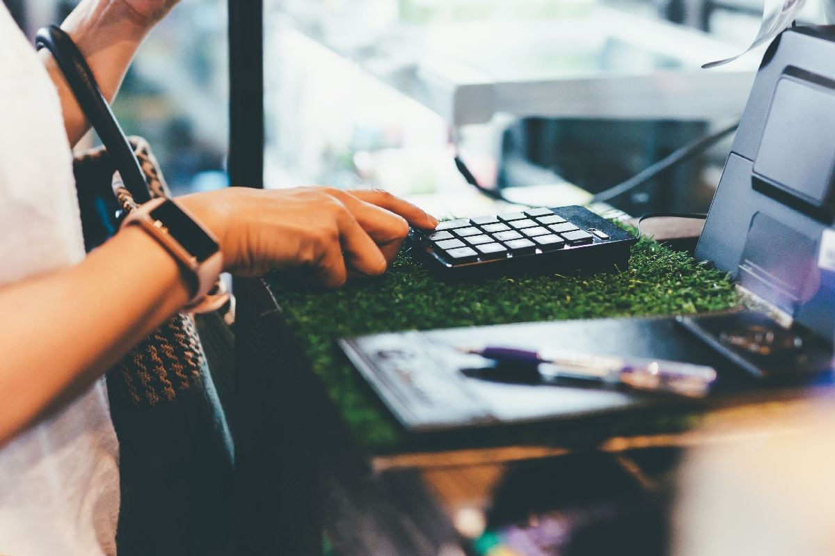 Customer enters the amount into the cash register in cafe.