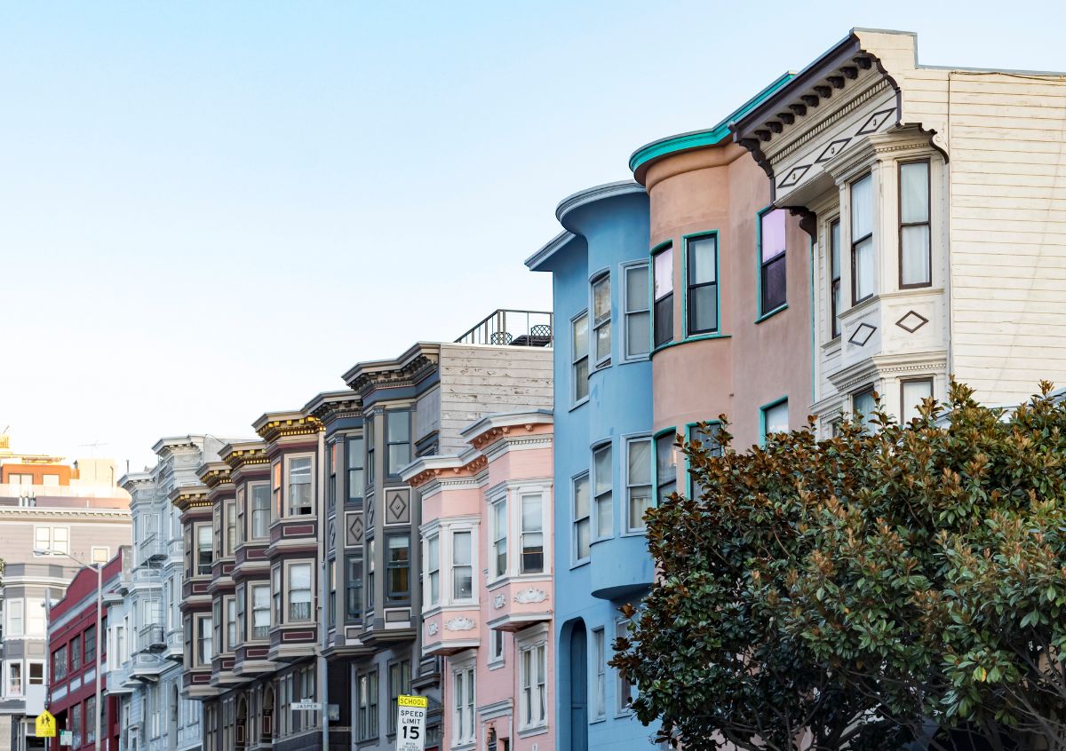 Row of historic pastel colored buildings with bay windows.